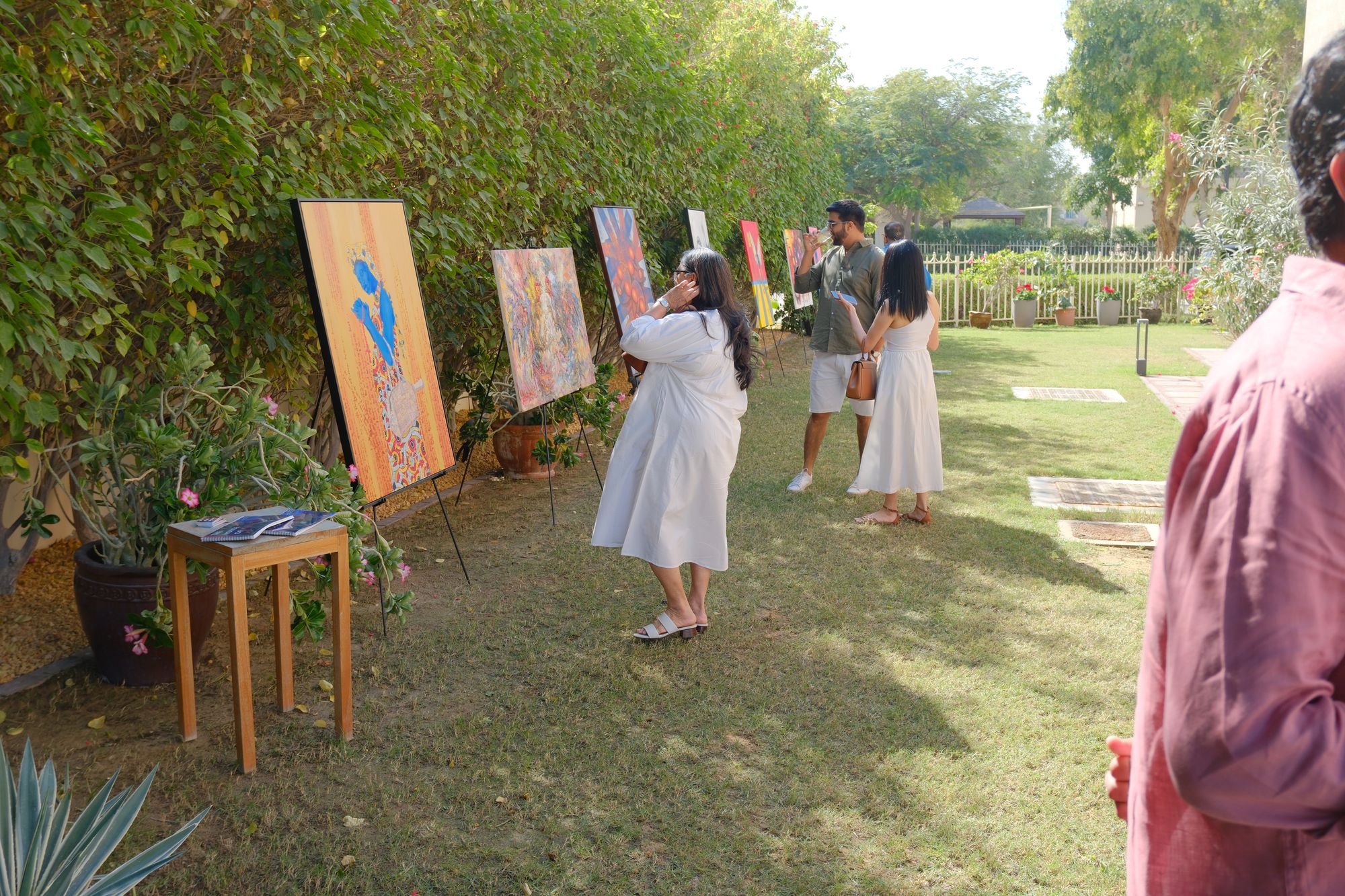 Paintings on easels along a garden wall in Dubai